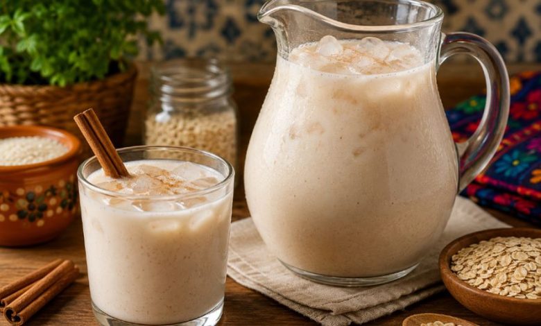Jarra y vaso con agua de horchata con avena, hielo y canela
